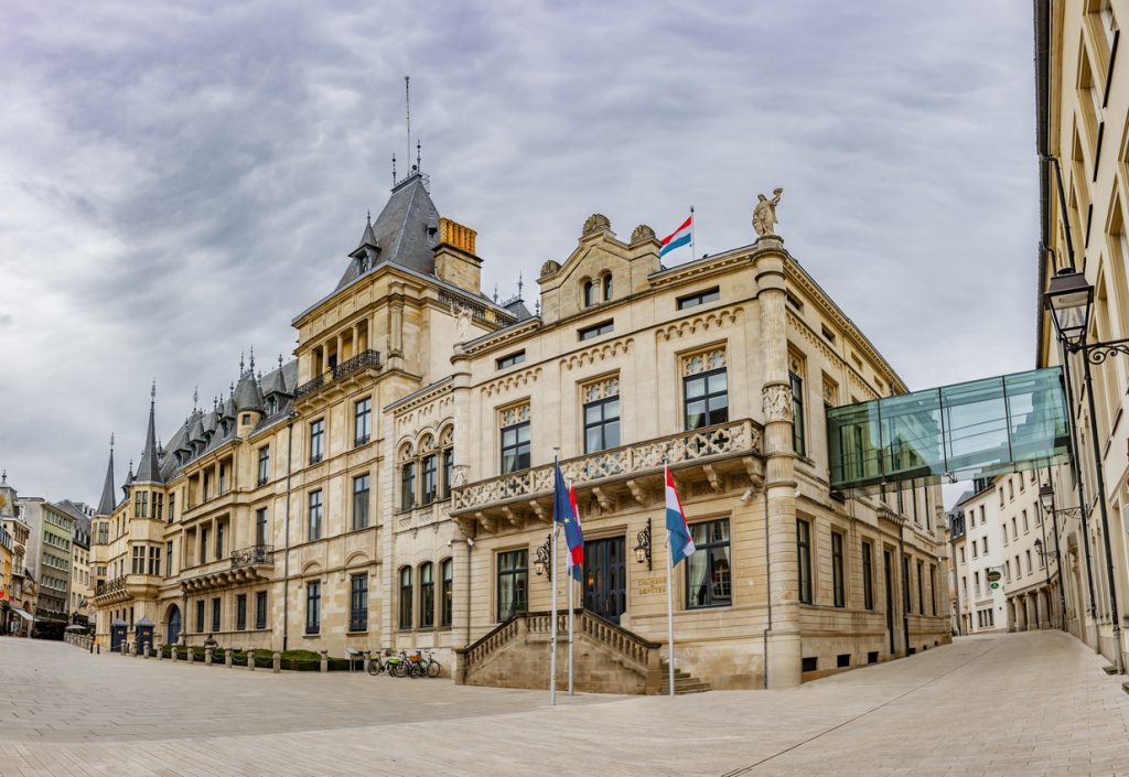 Gebäude der Chambre des Députés in Luxemburg Stadt mit Flaggen und steinerner Architektur.