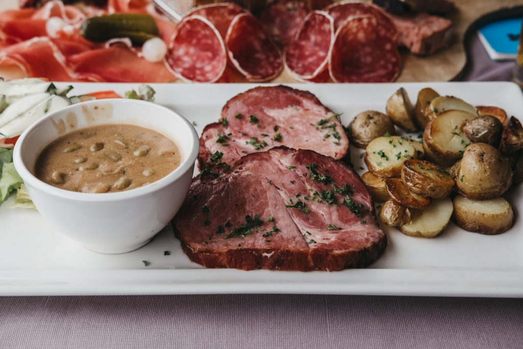 Teller mit geräuchertem Schweinefleisch, Kartoffeln und Bohnensauce als typisches Gericht aus Luxemburg.