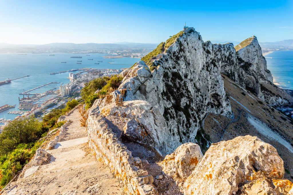 Schmaler Wanderweg führt über den Grat des Felsens von Gibraltar mit Blick auf Stadt und Meer.