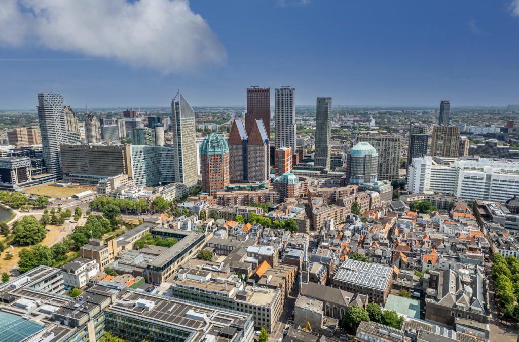 Panorama über Den Haag mit modernen Hochhäusern und dicht bebauter Altstadt an einem sonnigen Tag.
