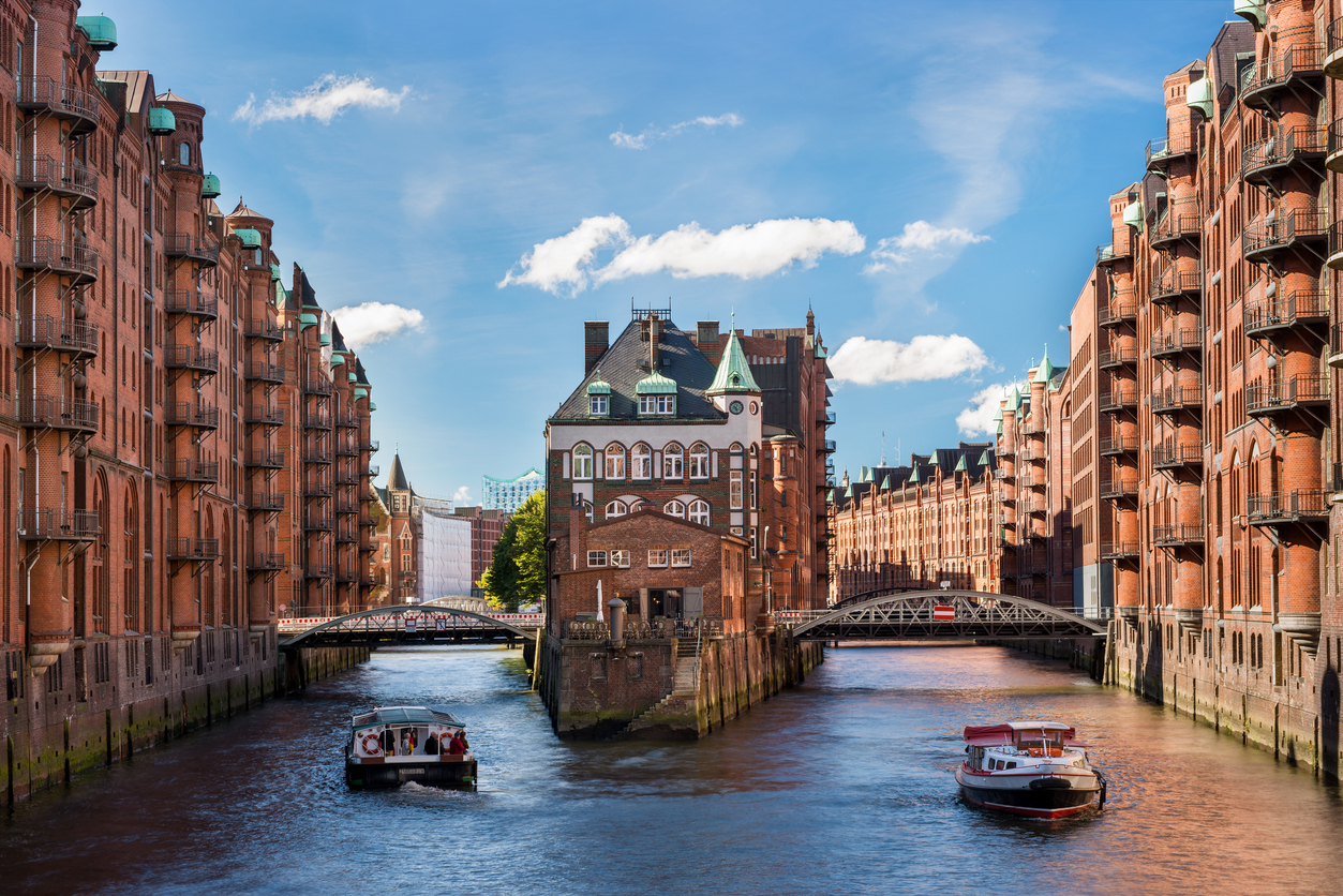 Ein Kanal in der Hamburger Speicherstadt führt zwischen Backsteinlagern in die Stadt.