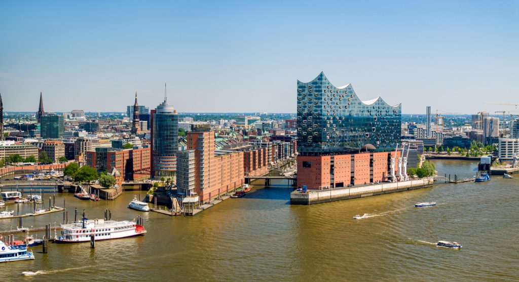 Die Elbphilharmonie in Hamburg steht am Wasser, davor fahren Boote auf der Elbe.