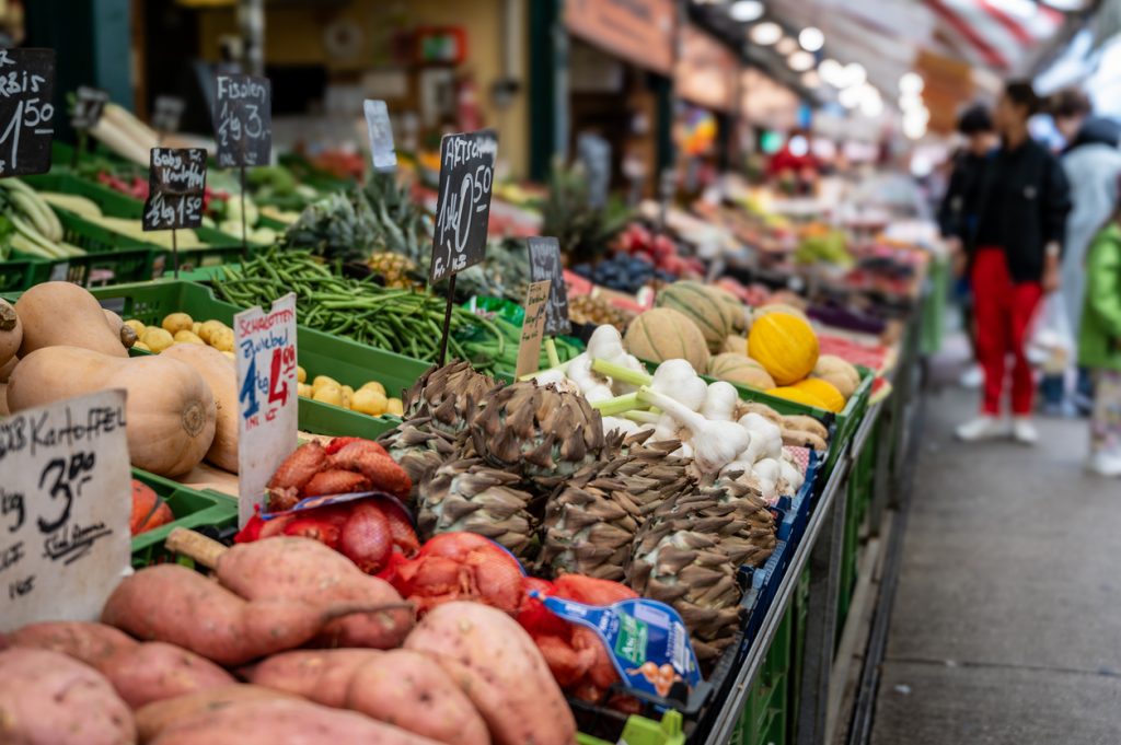 Nahaufnahme eines Gemüsestandes auf einem Wiener Markt mit vielen frischen Produkten.