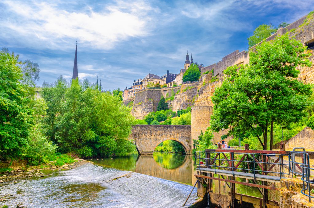 Blick auf die Altstadt von Luxemburg Stadt mit Flusstal, Brücke und historischen Mauern.