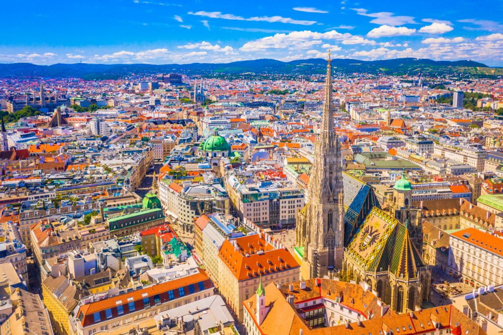Luftaufnahme mit dem Stephansdom und der Altstadt von Wien unter blauem Himmel.