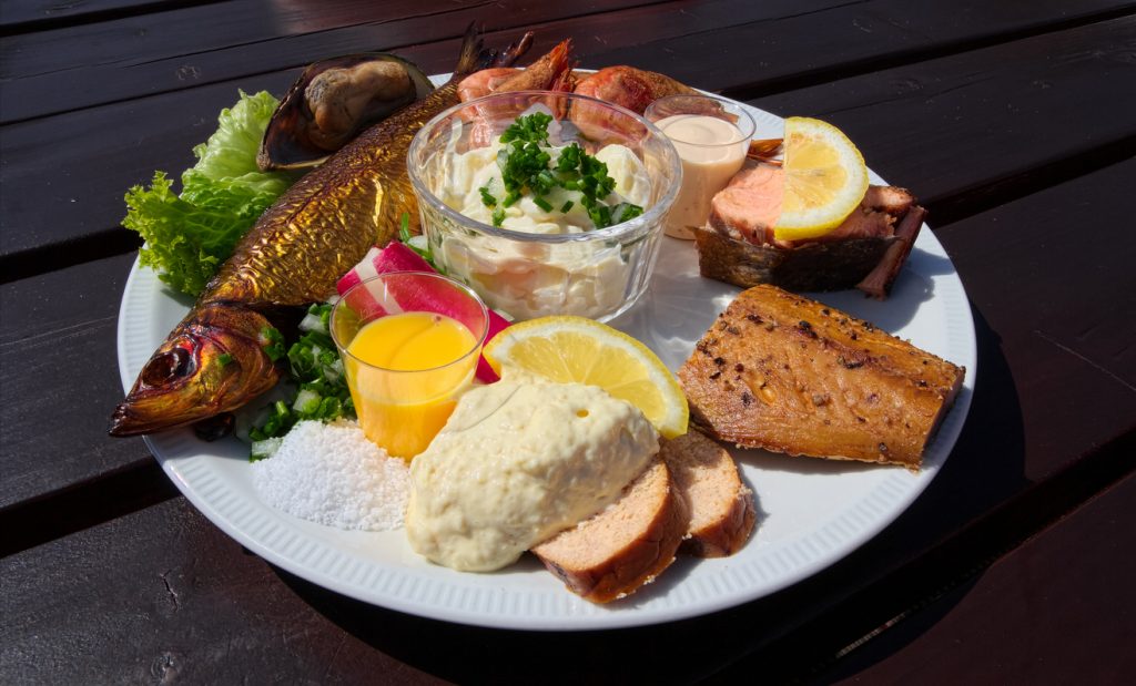 Große Platte mit Räucherfisch, Salaten und Saucen als typische Spezialität auf Bornholm.