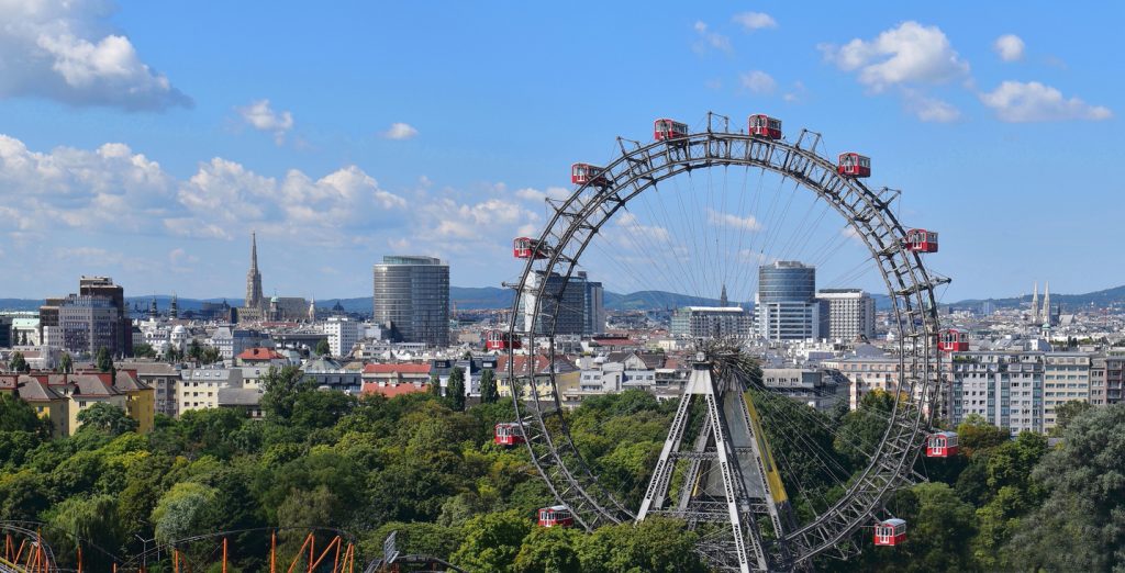 Panorama mit dem berühmten Riesenrad im Prater und der Skyline von Wien bei Tag.