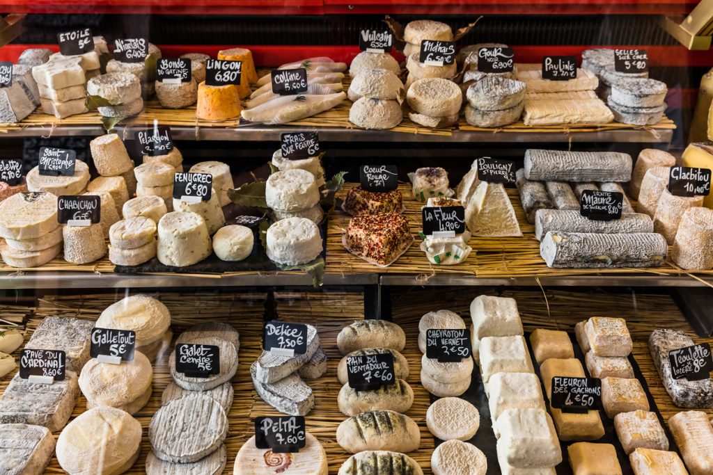 Auslage einer Fromagerie in Paris mit vielen verschiedenen französischen Käsesorten und Preisschildern.