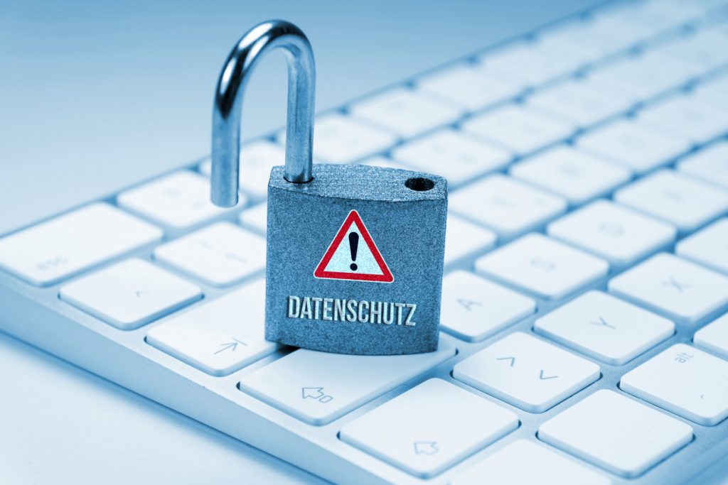 Offenes Vorhängeschloss mit dem Wort „Datenschutz“ steht auf einer Computer-Tastatur.
