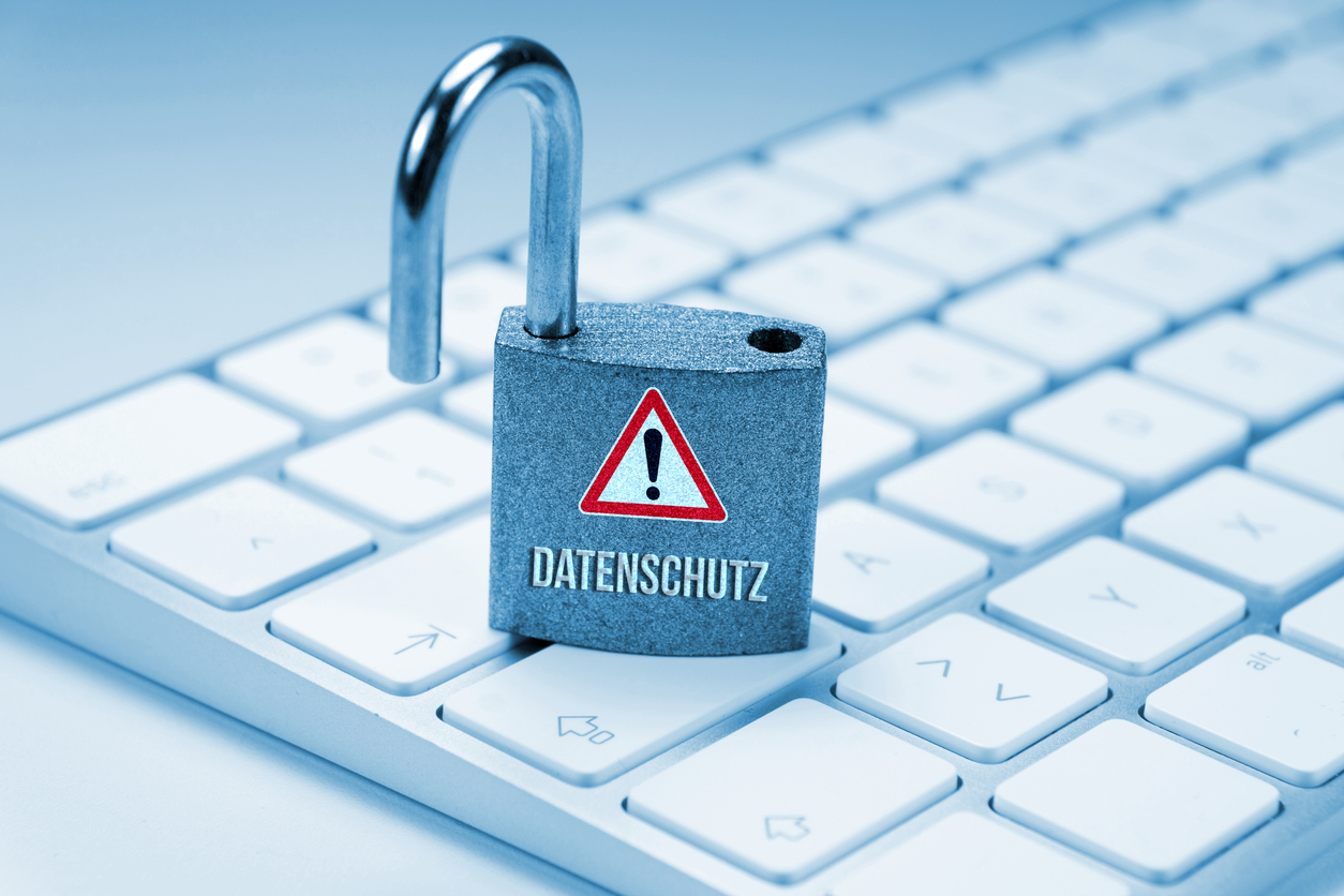 Offenes Vorhängeschloss mit dem Wort „Datenschutz“ steht auf einer Computer-Tastatur.