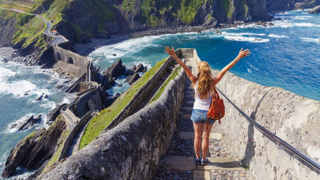 Eine Reisende steht auf den Stufen von San Juan de Gaztelugatxe nahe Bilbao.