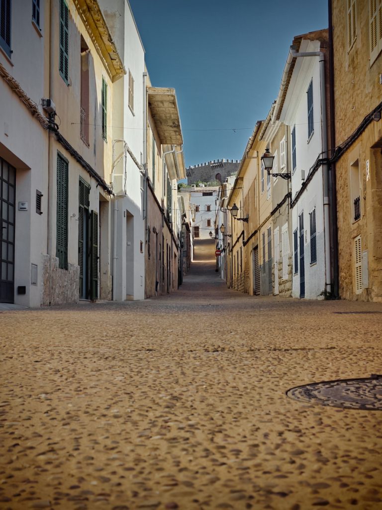 Leere Altstadtgasse in Capdepera mit Blick zur Burg am Ende der Straße.