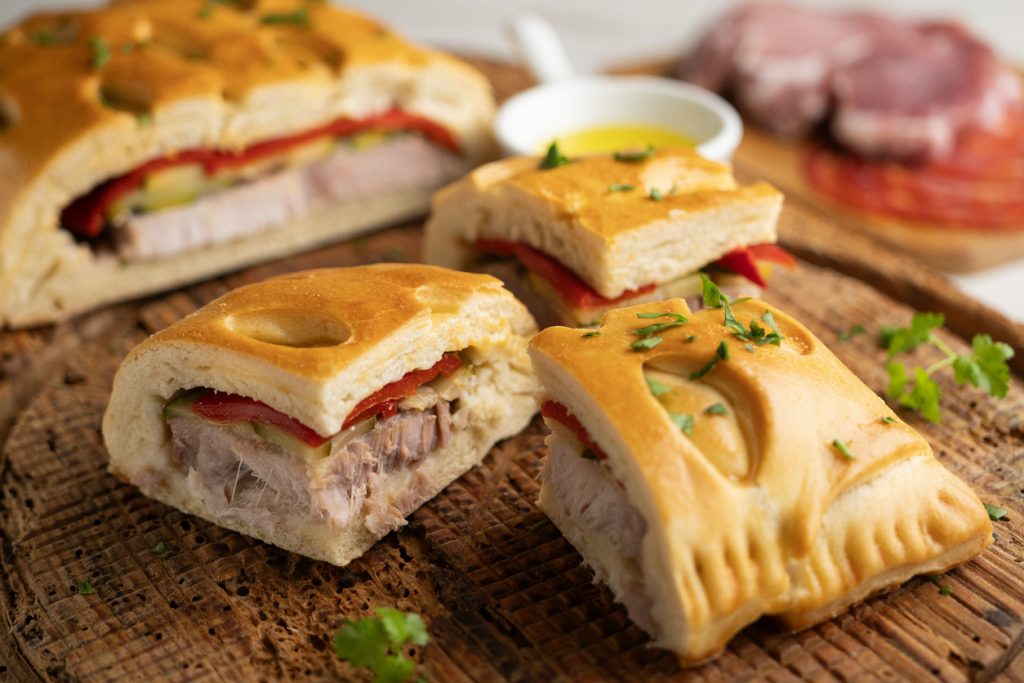 Gefülltes Gebäck mit Fleisch auf einem Holztisch.