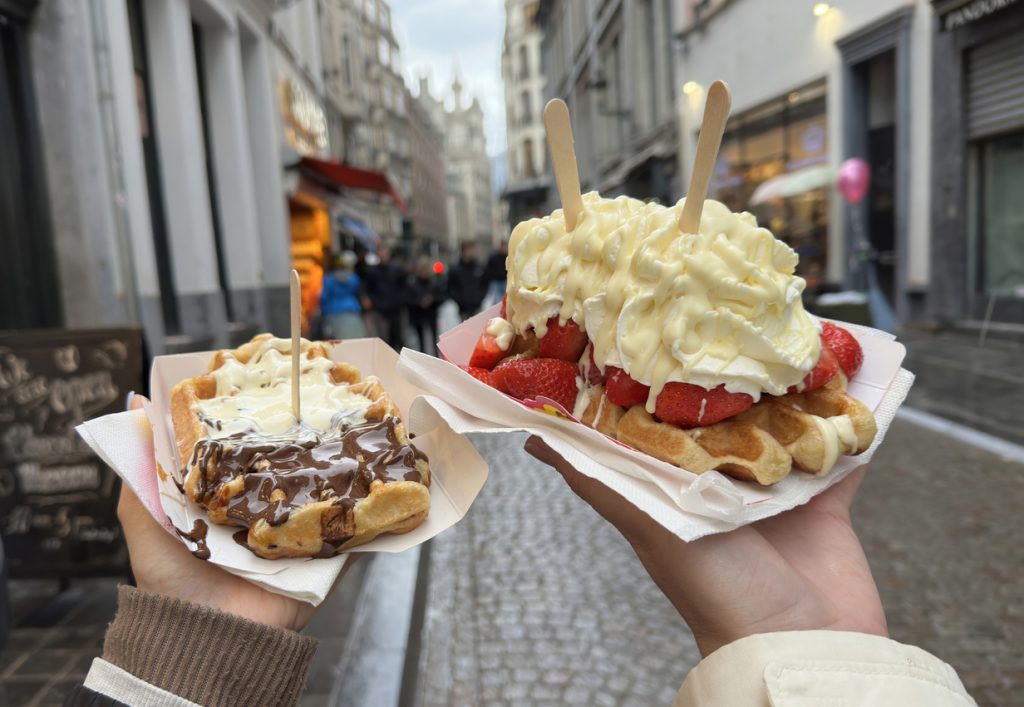 Belgische Waffeln mit Erdbeeren und Sahne in einer Altstadtstraße.
