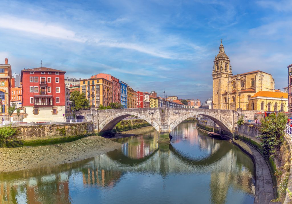 Steinbrücke und Kirche am Fluss in Bilbao, Spanien.