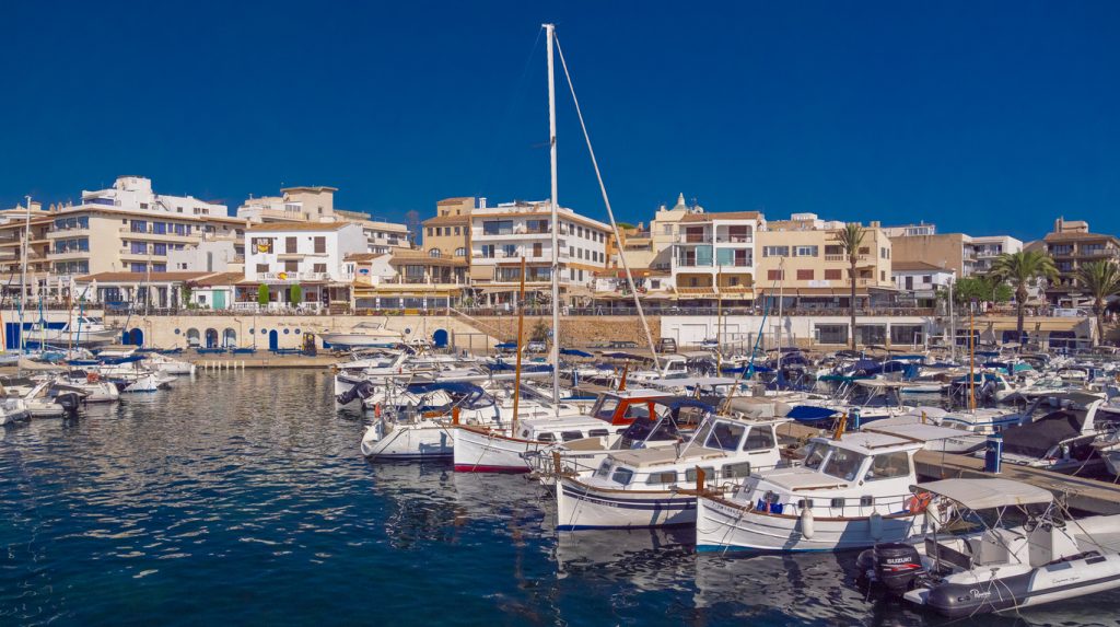 Yachthafen bei Capdepera mit vielen Booten vor der Uferpromenade.