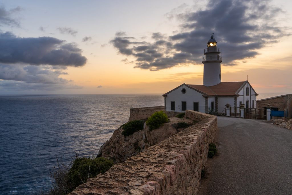 Leuchtturm von Capdepera auf einer Klippe über dem Meer im Abendlicht.