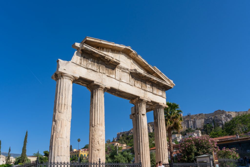 Ein antikes Tor mit hohen Säulen steht frei und wirkt wie ein Zeitfenster in die Vergangenheit.