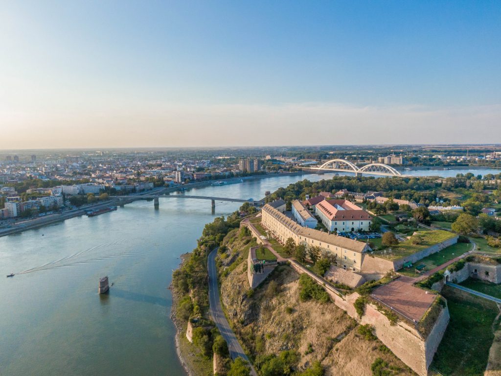 Ein weiter Blick über die Donau auf die massiven Mauern der Festung Petrovaradin und die Stadtbrücken.