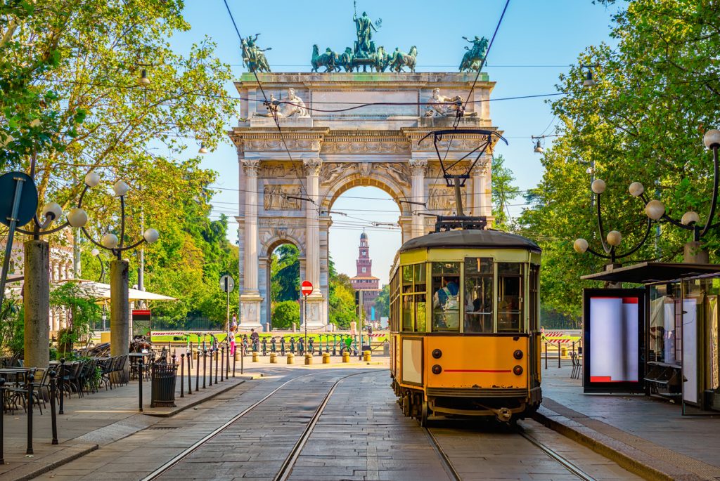 Historische Straßenbahn auf den Gleisen mit dem Arco della Pace im Hintergrund in Mailand.