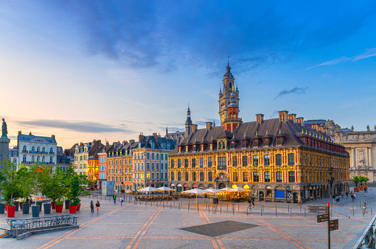 Der weitläufige Place du Général de Gaulle in der blauen Stunde mit beleuchteten historischen Fassaden und dem hohen Turm der Handelskammer im Hintergrund.