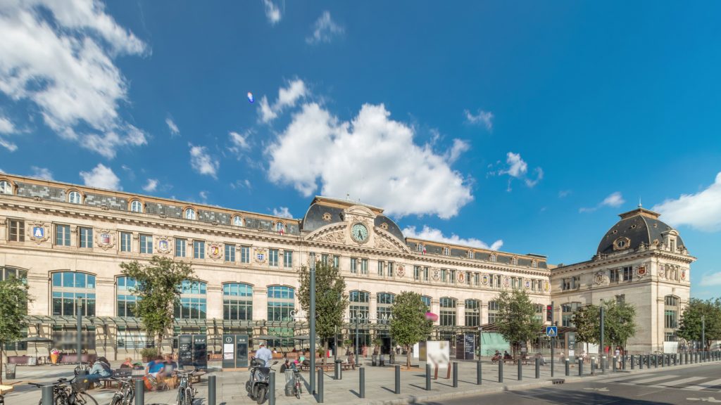 Der historische Bahnhof von Toulouse präsentiert sich mit einer kunstvollen Steinfassade und einer großen Uhr.