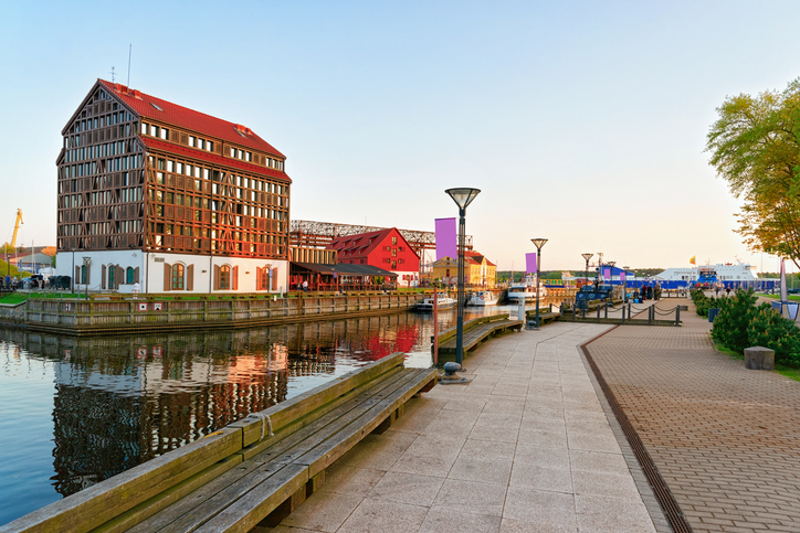 Eine breite Uferpromenade verläuft an Kanälen und historischen Hafenhäusern entlang.
