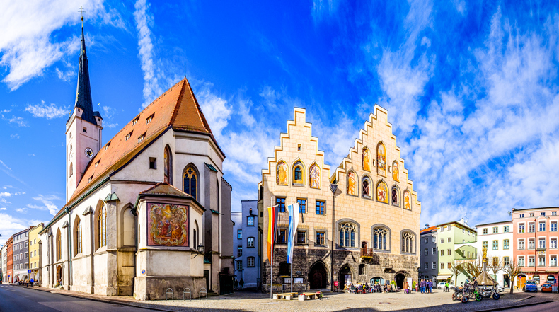 Ein sonniger Platz mit Blick auf die Stadtpfarrkirche St. Nikolaus und das alte Rathaus in Rosenheim.