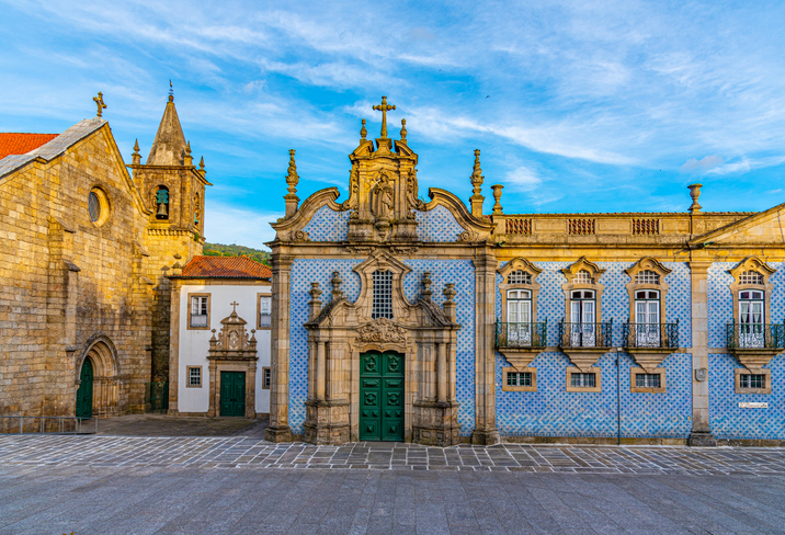 Die Fassade einer Kirche und eines angrenzenden Gebäudes, verziert mit den typisch blauen portugiesischen Kacheln.