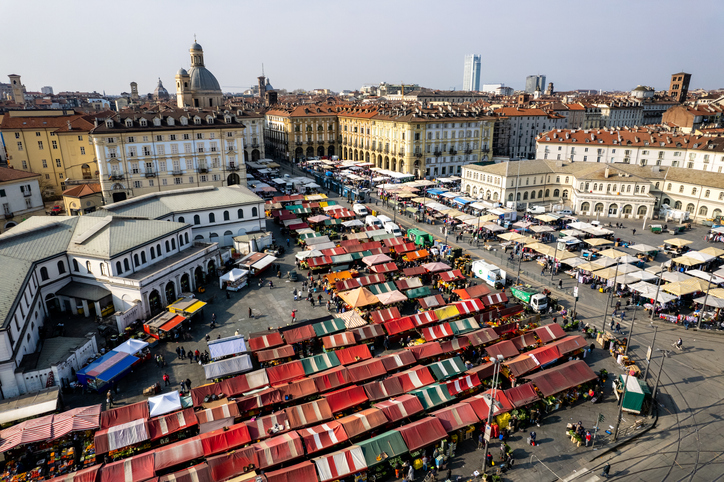 Viele Marktstände füllen einen großen Platz zwischen historischen Gebäuden.