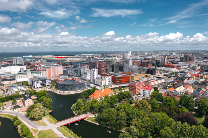 Eine Luftaufnahme des modernen Hafenviertels von Malmö mit Blick auf die Ostsee und markante Architektur unter Wolken.