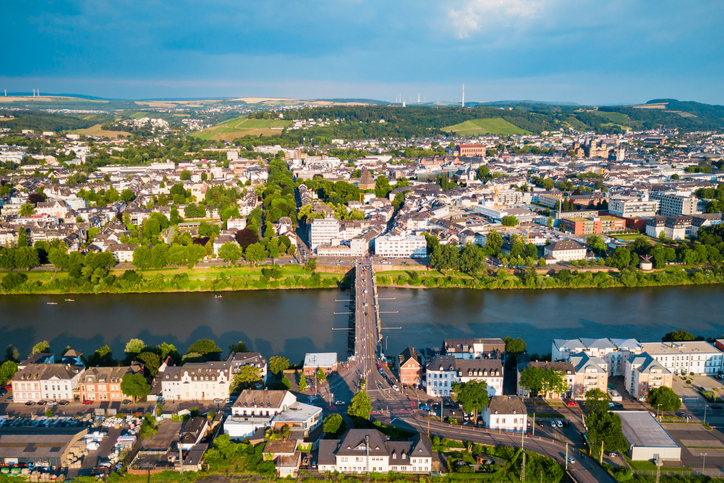 Ein breiter Fluss, eine Brücke und viele Häuser sind von oben zu sehen.