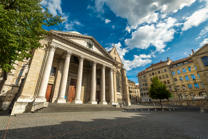 Ein großes steinernes Gebäude mit Säulen steht an einem fast leeren Platz.