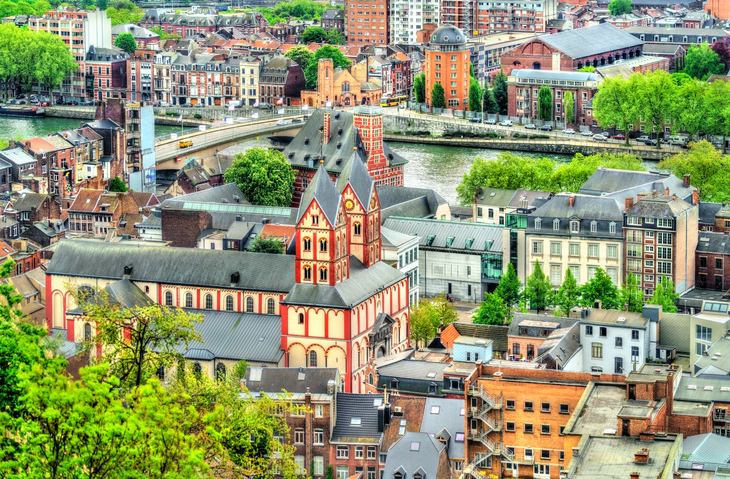 Blick von oben die steile Treppe Montagne de Bueren in Lüttich hinunter, flankiert von Häusern und mit Blick auf die Stadt.