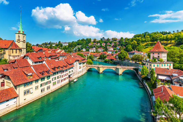 Blick über den Fluss Aare auf die historische Altstadt von Bern bei sonnigem Wetter