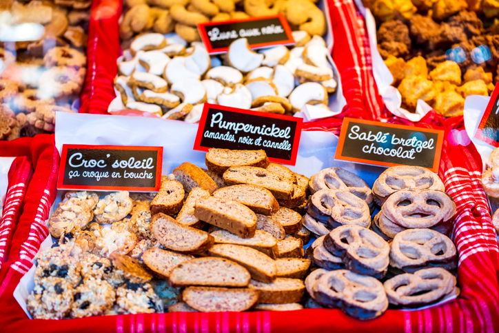 Verschiedene Sorten traditioneller Elsässer Weihnachtsplätzchen (Bredele) in einer Auslage mit Preisschildern.