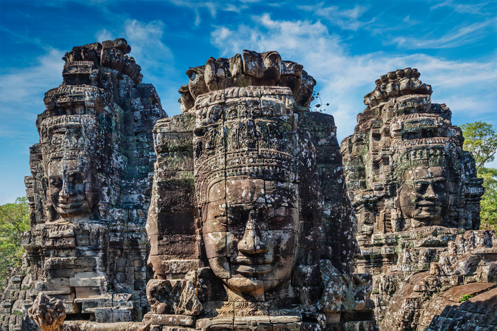 Großaufnahme der lächelnden Steingesichter an den Tempeltürmen des Bayon in Angkor Thom