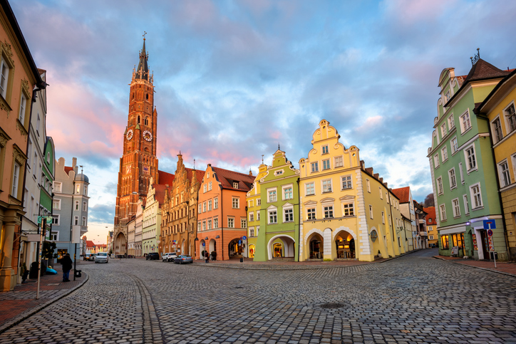 Kopfsteingepflasterte Altstadt von Landshut mit bunten Giebelhäusern und dem Kirchturm von St. Martin