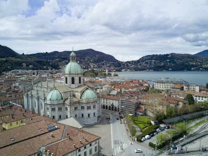 Luftaufnahme des Doms von Como mit seiner markanten grünen Kuppel und der Altstadt am Ufer