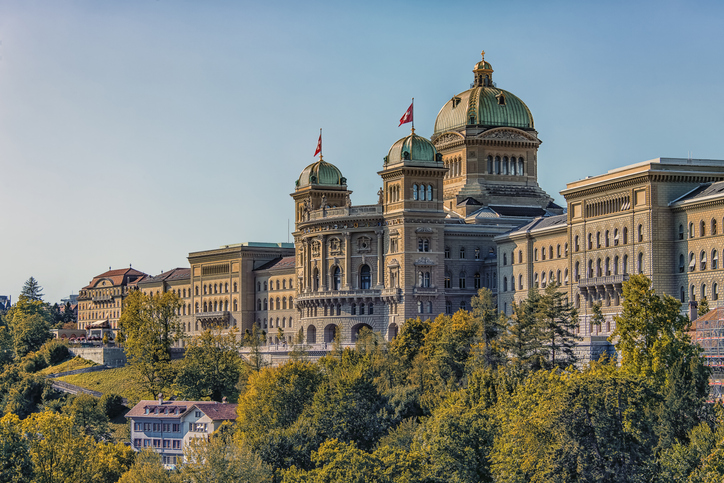 Das imposante Parlamentsgebäude in Bern umgeben von einer herbstlichen Parklandschaft