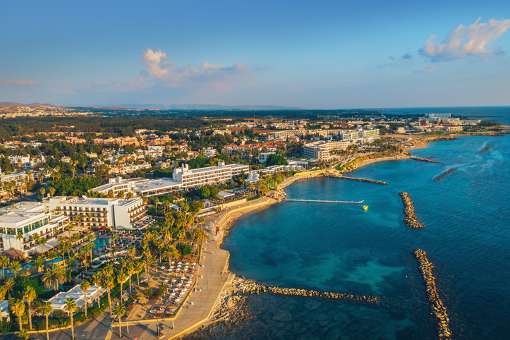 Eine weitläufige Bucht mit Palmen, Hotels und azurblauem Wasser während der goldenen Stunde.