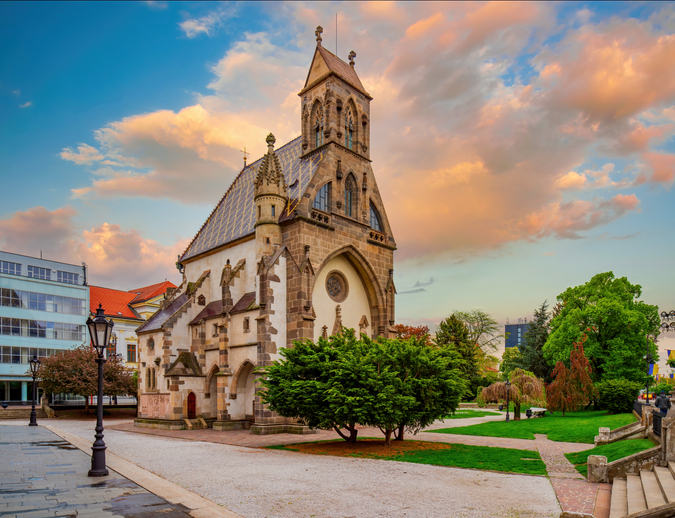 Die freistehende gotische Michaelskapelle in Košice, umgeben von einer gepflegten Parkanlage während der Goldenen Stunde.