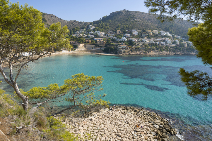 Eine idyllische Bucht mit klarem blauem Wasser und Blick auf die umliegenden Hügel in der Region Alicante