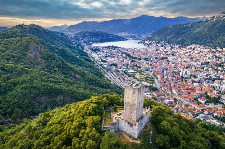 Blick von oben auf die Stadt Como am See mit dem markanten Turm des Castello Baradello im Vordergrund
