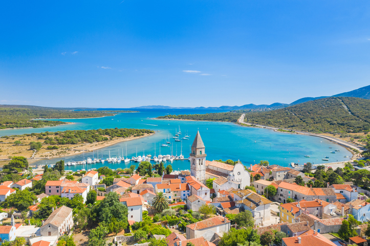Luftaufnahme der Stadt Osor, die Cres mit der Nachbarinsel verbindet, umgeben von tiefblauem Meer.