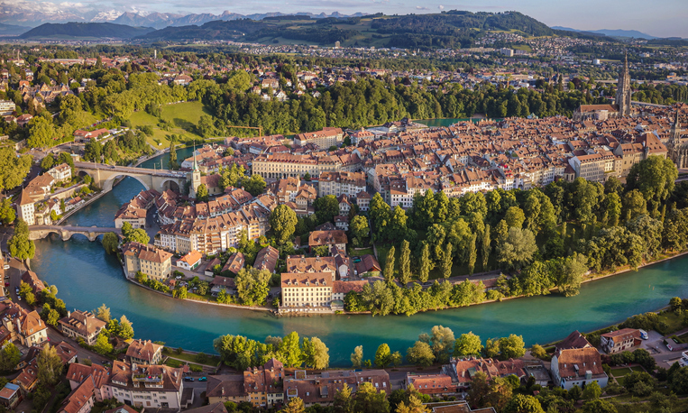 Luftaufnahme der roten Dächer der Berner Altstadt und der Aare