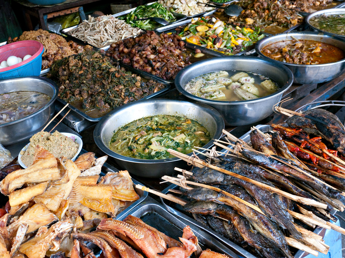 Eine reiche Auswahl an gebratenen Fischen, traditionellen Suppen und gegrillten Speisen an einem Marktstand in Kambodscha