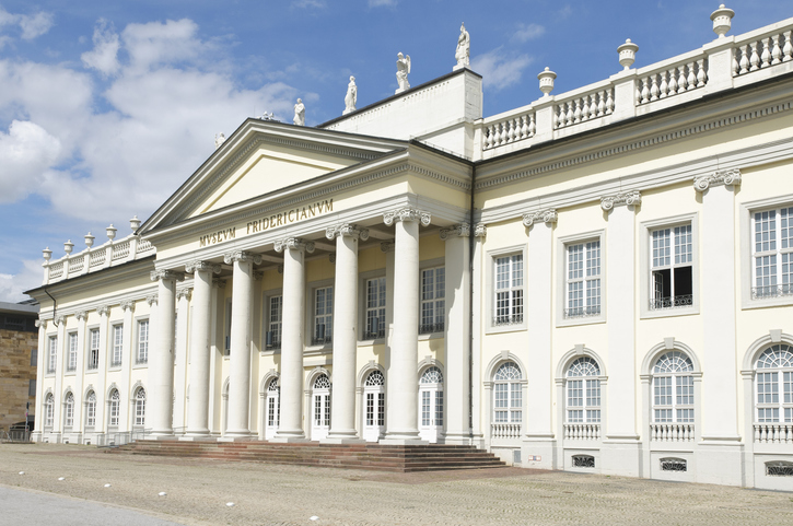 Die klassizistische Fassade des Museum Fridericianum mit seinen markanten weißen Säulen und Statuen auf dem Dach.