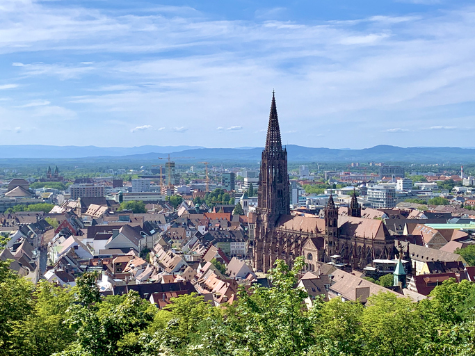 Weite Aussicht vom Schlossberg auf das Freiburger Münster und das Rheintal in der Ferne.