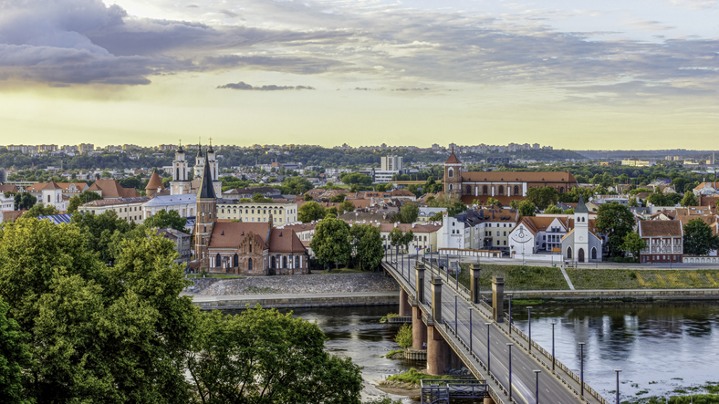 Eine moderne Straßenbrücke führt über den Fluss direkt auf die Silhouette der Altstadt mit ihren vielen Kirchtürmen zu.
